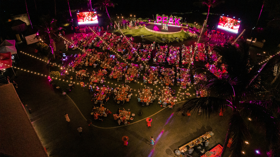 Bird's eye view photo of hundreds of guests outside at dining tables with T-Mobile PEAK Branding