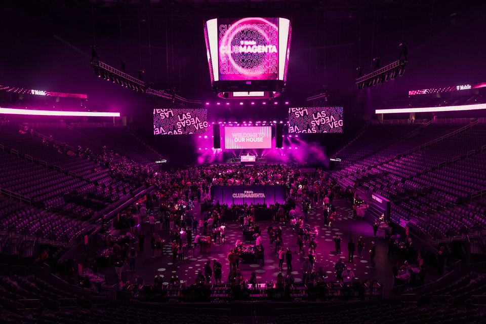 Interior photo of T-Mobile arena with T-Mobile club magenta - Las Vegas branding and guests standing on the floor area of the stadium