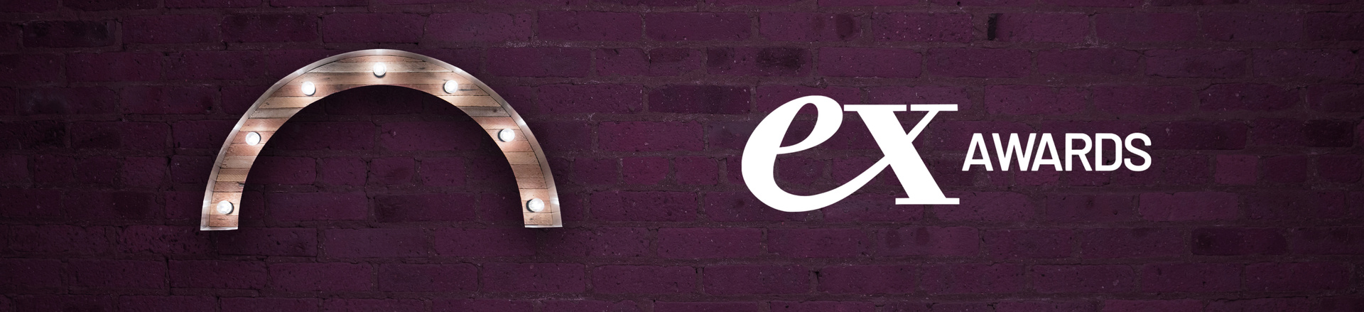 Marquee-style arch Proscenium logo and ex awards logo on a plum-colored brick wall background.