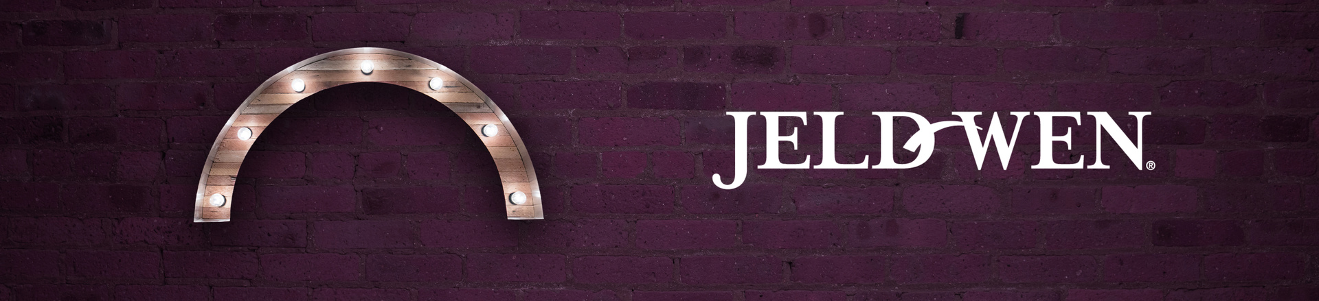 Marquee-style arch Proscenium logo and JELD-WEN logo on a plum-colored brick wall background.