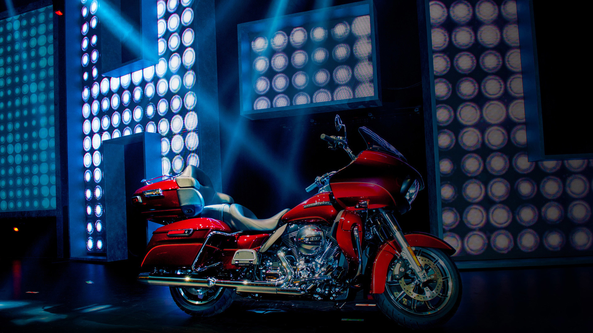 Photo shows a Beauty shot of red motorcycle with Harley Davidson H-D logo in background