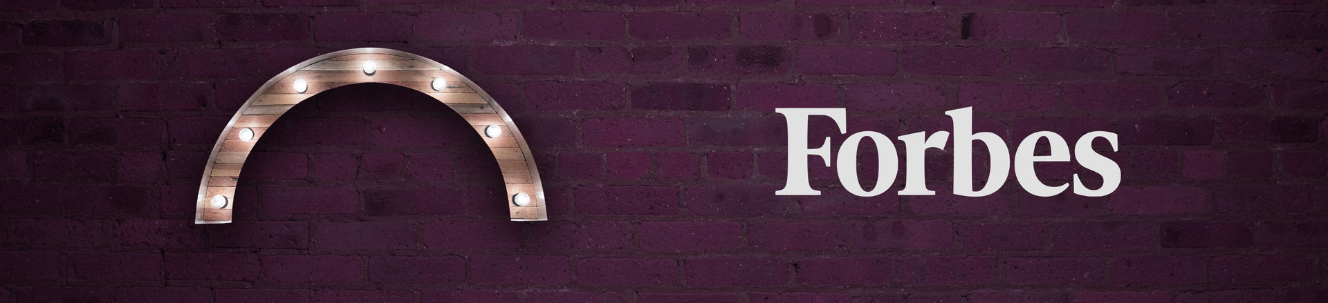 Marquee-style arch Proscenium logo and Forbes logo on a plum-colored brick wall background.