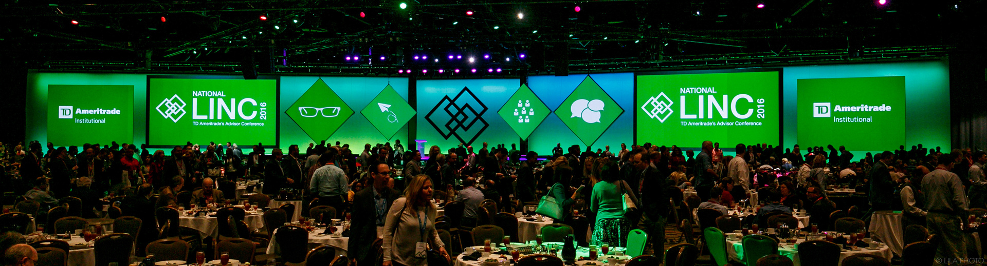 Photo of TD Ameritrade's Advisor Conference, National LINC 2016 Stage with a large audience. The stage is empty with a five Screen Configuration and green lighting.