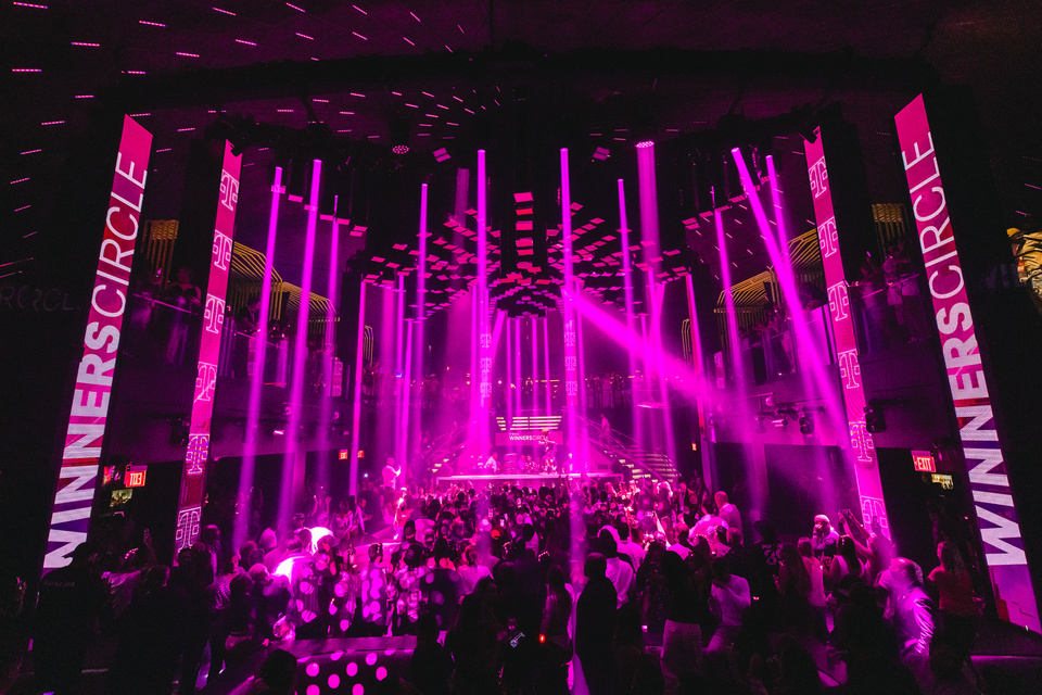 Photo in a night club: Two Banners with Winners Circle branding, Two Banners with T-Mobile Logos, Magenta Strips on Light are Flashing Down