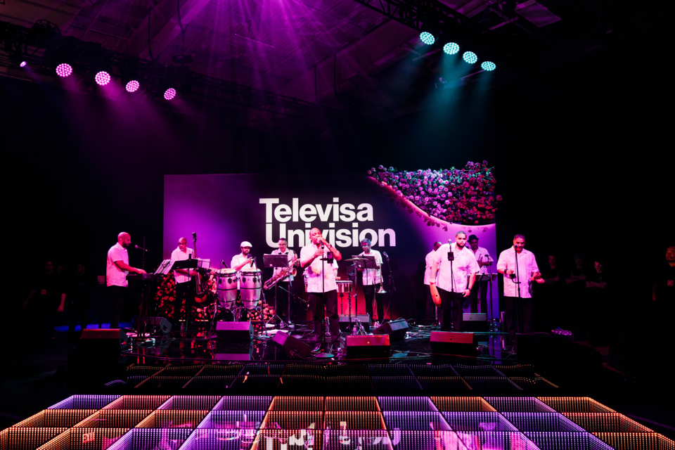 Photo of a jazz band performing on stage in front of LED screen showing Televisa Univision logo