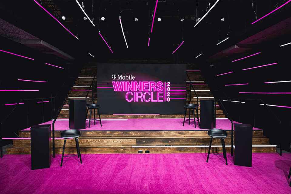 Photo of two-tier Magenta carpeted stage with T-Mobile Winner Circle 2020 displayed on a TV